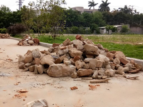 志愿者辛苦劳作,整理空地上的大石块